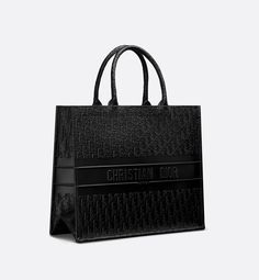 Introduced by Maria Grazia Chiuri, Creative Director of Christian Dior, the Dior Book Tote has become a staple of the Dior aesthetic. Designed to hold all the daily essentials, the black calfskin style is embossed with a Dior Oblique motif and is further enhanced by the Christian Dior Paris signature on the front. The large tote exemplifies the House's signature savoir-faire and may be carried by hand or worn over the shoulder.. Christian Dior Bag Totes, Black Dior Bag, Christian Dior Tote, 1800s Dresses, Dior Tote Bag, Future Christmas, Christian Dior Bag, Bag Boutique, Dior Aesthetic