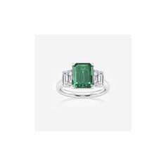 an emerald and diamond ring with two baguets on the shoulders, set in white gold