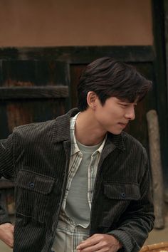 a young man standing in front of a pizza