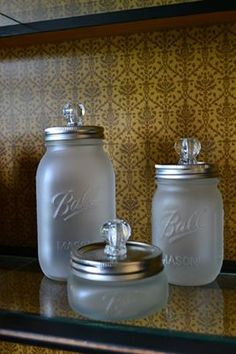 two glass jars sitting on top of a shelf