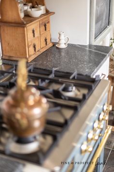 a stove top oven sitting inside of a kitchen next to a wooden cabinet and counter