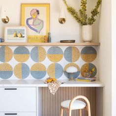 a white desk topped with a wooden chair next to a shelf filled with pictures and vases