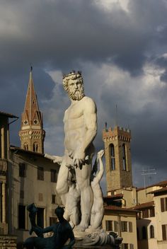 the statue is in front of an old building