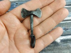 a hand holding an old metal hammer in it's palm