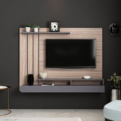 a living room with black walls and a tv mounted on the wall, along with a clock