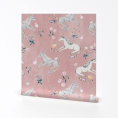 a pink wrapping paper with unicorns and flowers on it, against a white background