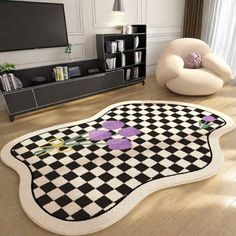 a living room with a black and white checkered rug on the floor next to a chair