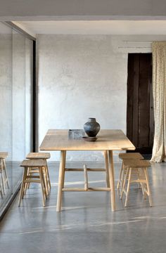 a table with chairs and a vase on it