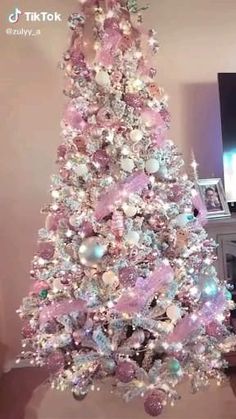 a pink and white christmas tree in a living room