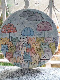 a plate with cats and umbrellas painted on it