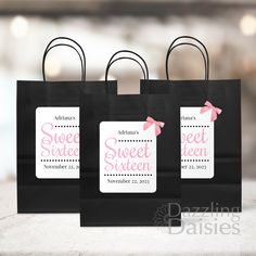 three black shopping bags with pink bows and the words sweet sixteen printed on them are sitting on a table