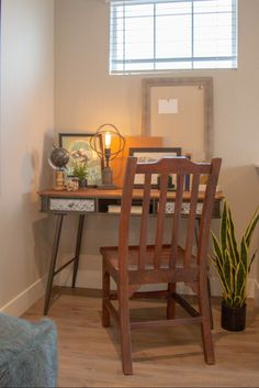 a wooden chair sitting in front of a desk with a lamp on top of it