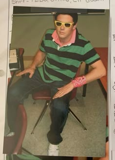 a man sitting on top of a chair in front of a computer desk wearing sunglasses