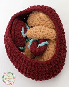 a crocheted basket with two stuffed animals in it