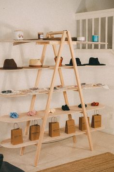 a wooden shelf with hats and bags on it in front of a wall mounted shelving unit