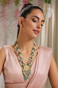 The multicolored stone necklace with a Kundan pendant featuring blue and green stones is elegantly handcrafted by the artisans to give a touch of rich old Indian jewelry. The long necklace embossed with beads and shell pearls can be gracefully paired with your ethnic or contemporary ensembles to give you a royal look. This masterpiece necklace creates a balance between the new traditional and old-world beauty. Necklace Closure - Adjustable Dori Style Tip - Looks best when worn with your royal wh Fusion Style Blue Necklace For Festive Occasions, Green Temple Jewelry Style Pearl Necklace As Gift, Green Temple Jewelry Pearl Necklace As Gift, Festive Green Necklace With Pearl Pendant, Green Gemstone Beaded Necklaces For Wedding, Festive Blue Gemstone Bead Jewelry, Green Temple Jewelry Necklaces With Stones, Green Temple Jewelry Necklace With Stones, Festive Blue Gemstone Beads Necklace