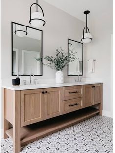 a bathroom with two sinks and mirrors on the wall