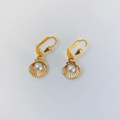 Gold Plated seashell and faux pearl earrings. These earrings dangle from a gold plated lever back setting. Very pretty earrings! Elegant Gold Shell With Lobster Clasp, Gold Shell Earrings With Pearl Charm, Gold Pearl Drop Earrings In Shell Shape, Gold Dangle Shell Earrings With Pearl Drop, Elegant Gold Dangle Shell Earrings, Elegant Gold Dangle Shell, Celtic Circle, Celtic Knot Earrings, Marble Earrings