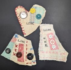 three pieces of fabric with buttons and words on them sitting next to each other in front of a black background