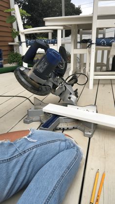 a person laying on the ground with a power tool