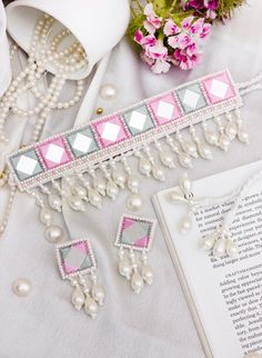 a pink and silver beaded bracelet with pearls on it next to a bouquet of flowers