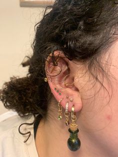 a close up of a person with ear piercings on their ears and wearing jewelry