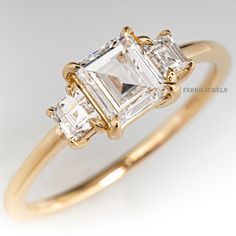 a three stone ring with an emerald cut diamond in the center and two baguettes on each side