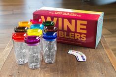 the wine tumblers are lined up on the table next to the box and stickers