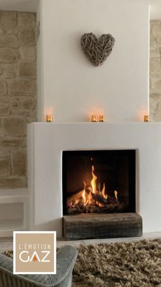 a living room with a fire place in the middle and a heart on the wall