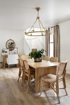 a dining room table with chairs and a potted plant on it's end