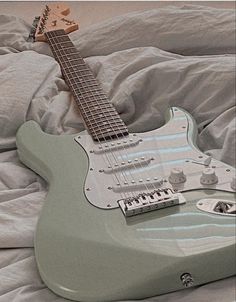 an electric guitar laying on top of a bed