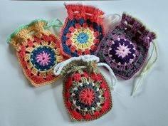 four crocheted bags sitting on top of a table