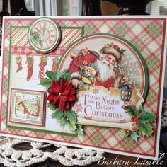 a christmas card with santa clause and holly wreaths on the front, sitting next to a window