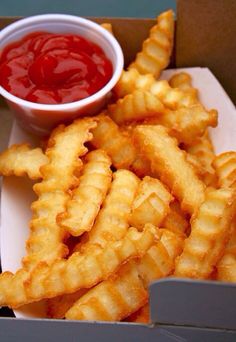 a box filled with fries and ketchup on top of a table