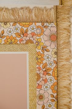 a photo frame with flowers and fringes on it