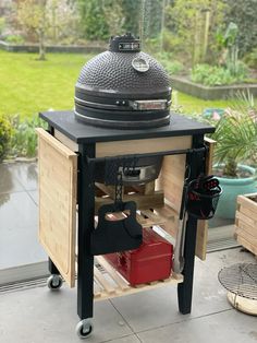 an outdoor bbq grill on wheels with the door open to show it's contents