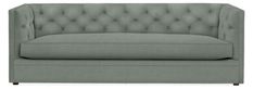 a gray couch with buttons on the back and arm rests against a white background,