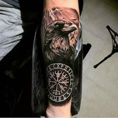 a man with a tattoo on his arm has an eagle and compass in the background