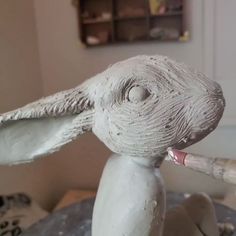 a close up of a sculpture of a rabbit holding a paintbrush