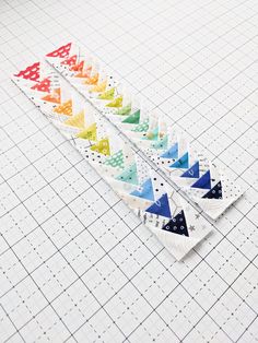 a row of different colored triangles sitting on top of a white tiled floor next to each other