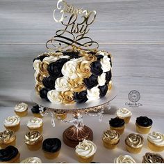 a cake and cupcakes on a table with the words happy birthday written in gold