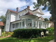 a large white house sitting on top of a lush green field