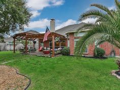 a house with an american flag on the front lawn and covered patio area in front of it