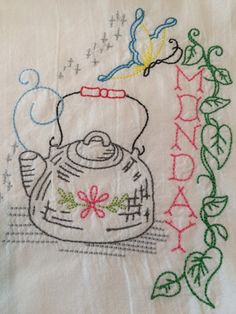 an embroidered tea towel with a kettle on it