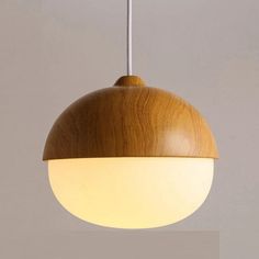 a wooden light hanging from a ceiling with a white wall in the backround