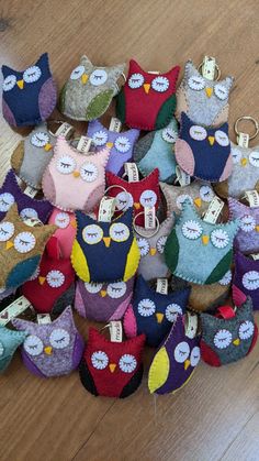 a pile of small stuffed owls sitting on top of a wooden floor