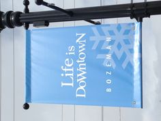 a blue sign hanging from the side of a light pole with snowflakes on it