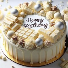 a birthday cake with white frosting and candies around it that says happy birthday