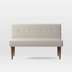 an upholstered bench with wooden legs and buttons on the back, against a white background