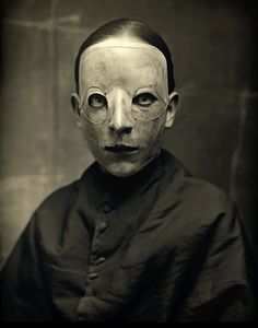 an old photo of a man with glasses and a mask on it's face